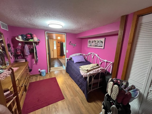 5940 150th Ave NE, New London Twp, MN 56288 - bedroom featuring wood finished floors and a textured ceiling