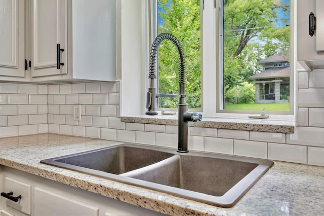 101 Sunset Dr S, Minnetonka, MN 55305 - kitchen view of decorative backsplash, white cabinets, and light stone counters