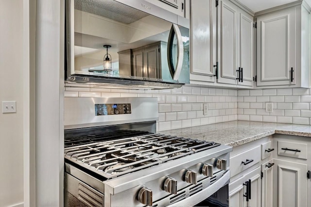 101 Sunset Dr S, Minnetonka, MN 55305 - kitchen featuring appliances with stainless steel finishes, decorative backsplash, and light stone counters