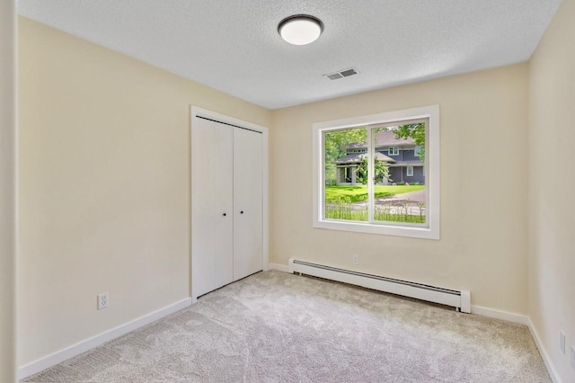 101 Sunset Dr S, Minnetonka, MN 55305 - unfurnished bedroom featuring a baseboard heating unit, carpet floors, a textured ceiling, and a closet