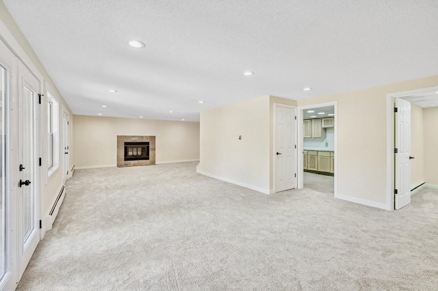 101 Sunset Dr S, Minnetonka, MN 55305 - unfurnished living room with a baseboard heating unit, light carpet, recessed lighting, a tile fireplace, and a textured ceiling