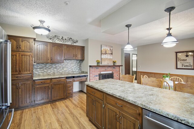 20128 554th St, Concord Twp, MN 55985 - kitchen featuring a textured ceiling, light countertops, dishwasher, pendant lighting, and light wood-type flooring