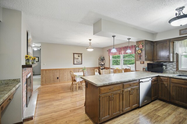 20128 554th St, Concord Twp, MN 55985 - kitchen featuring dishwasher, light wood-style flooring, a wainscoted wall, a peninsula, and a textured ceiling