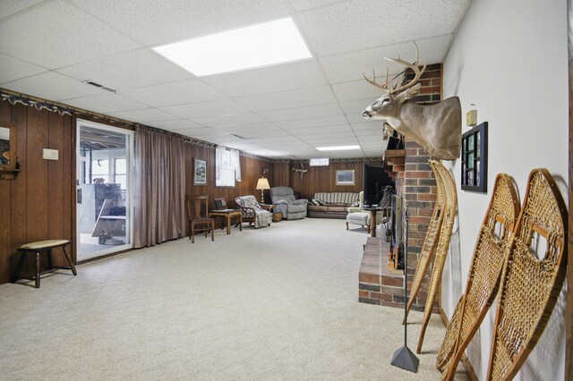 20128 554th St, Concord Twp, MN 55985 - living area with a drop ceiling, carpet, wooden walls, and a fireplace