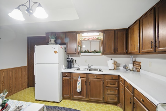 20128 554th St, Concord Twp, MN 55985 - kitchen with freestanding refrigerator, light flooring, light countertops, a wainscoted wall, and a chandelier