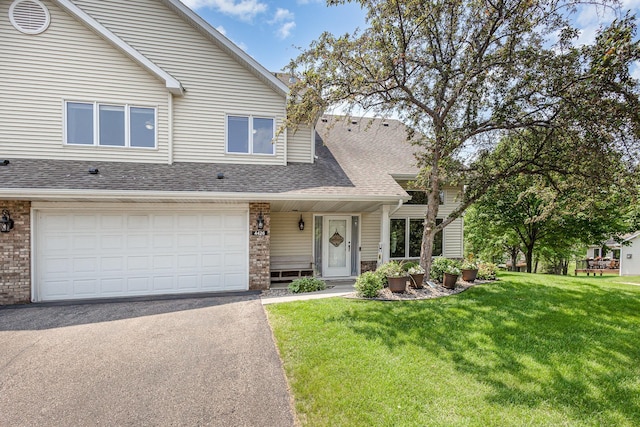 4426 Lakeshore Ter, Eagan, MN 55122 - view of front of house with brick siding, a shingled roof, driveway, a front yard, and an attached garage
