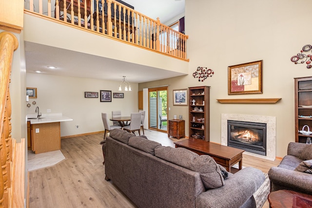 4426 Lakeshore Ter, Eagan, MN 55122 - living room featuring a glass covered fireplace, light wood finished floors, and a towering ceiling