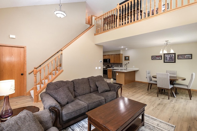 4426 Lakeshore Ter, Eagan, MN 55122 - living room with a towering ceiling, stairs, light wood-style flooring, and a chandelier