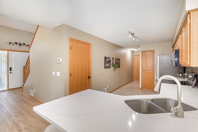 4426 Lakeshore Ter, Eagan, MN 55122 - kitchen with stainless steel microwave, a peninsula, light wood-style floors, stove, and a textured ceiling