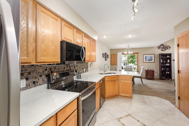4426 Lakeshore Ter, Eagan, MN 55122 - kitchen with appliances with stainless steel finishes, a peninsula, backsplash, and light tile patterned flooring