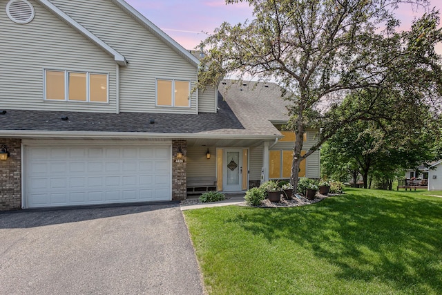 4426 Lakeshore Ter, Eagan, MN 55122 - view of front of property with asphalt driveway, a yard, a shingled roof, and a garage