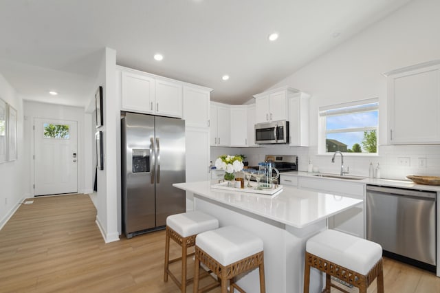 26639 8th St W, Zimmerman, MN 55398 - kitchen featuring appliances with stainless steel finishes, backsplash, a kitchen breakfast bar, healthy amount of natural light, and recessed lighting