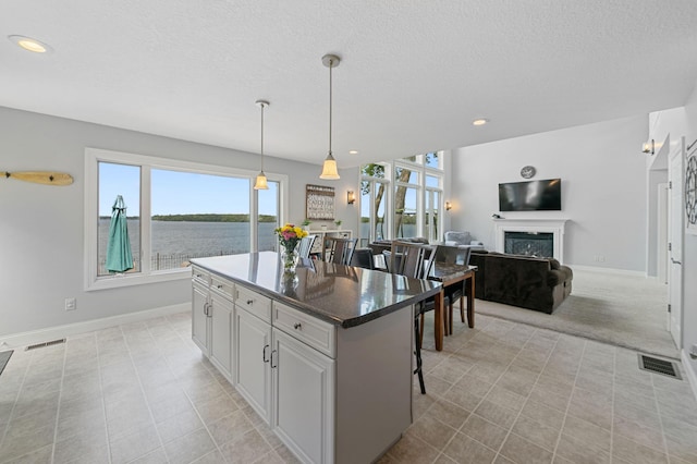 10460 Kismet Isle, Chisago Lake Twp, MN 55013 - kitchen featuring a kitchen island, a fireplace, a kitchen breakfast bar, hanging light fixtures, and recessed lighting