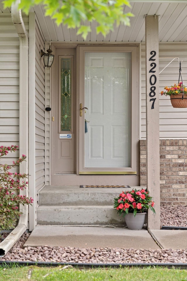 22087 Jasmine Way, Rogers, MN 55374 - view of exterior entry featuring a porch and brick siding