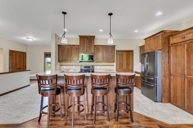 1301 20th Ave S, Sartell, MN 56377 - kitchen featuring stainless steel appliances, decorative backsplash, an island with sink, a breakfast bar, and recessed lighting