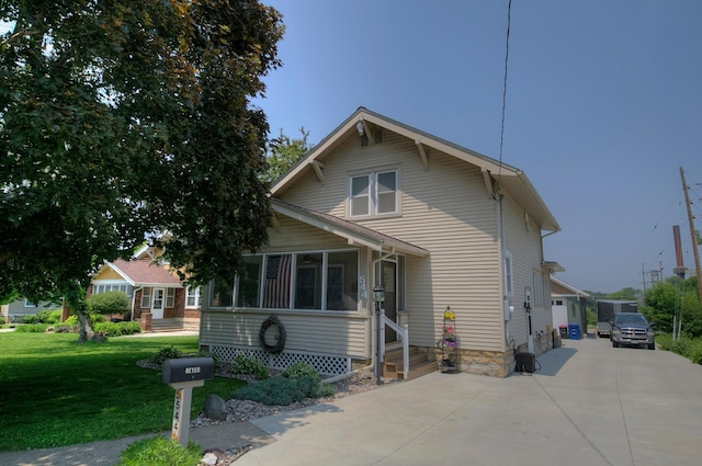 544 7th St, Red Wing, MN 55066 - bungalow-style house with concrete driveway, a front lawn, a sunroom, and entry steps