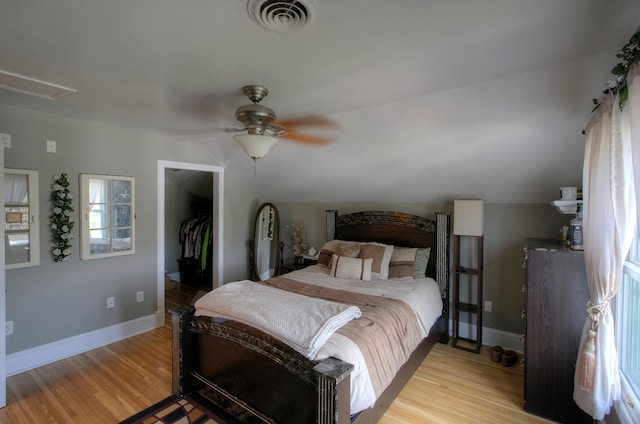 544 7th St, Red Wing, MN 55066 - bedroom with light wood-type flooring, a walk in closet, and multiple windows