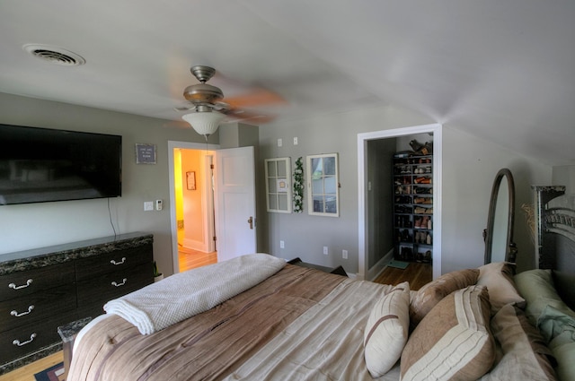 544 7th St, Red Wing, MN 55066 - bedroom with a walk in closet, wood finished floors, a closet, vaulted ceiling, and ceiling fan