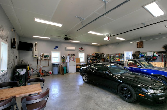 544 7th St, Red Wing, MN 55066 - garage with freestanding refrigerator, a garage door opener, a ceiling fan, and a wall unit AC
