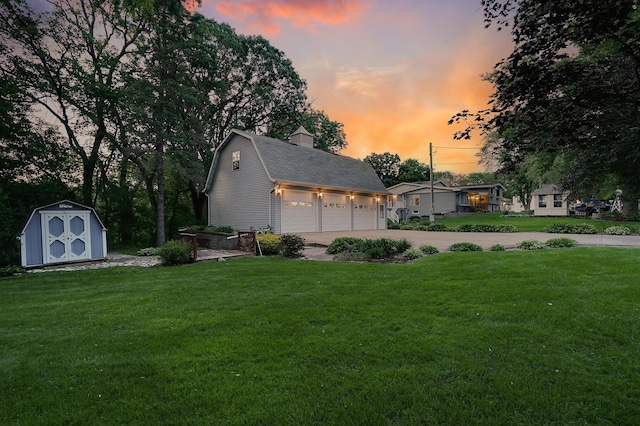 108 1st St, Kenyon, MN 55946 - view of front of property featuring a front lawn, a gambrel roof, a chimney, concrete driveway, and roof with shingles