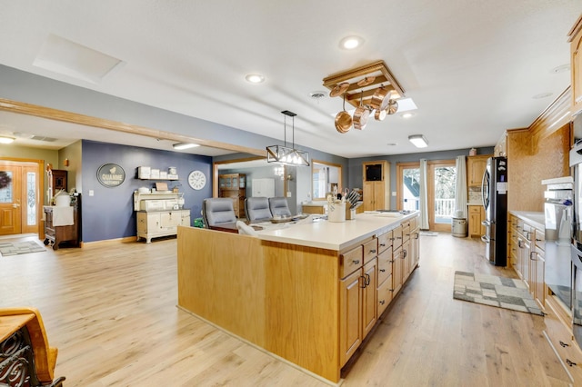 108 1st St, Kenyon, MN 55946 - kitchen with freestanding refrigerator, light wood finished floors, light countertops, open floor plan, and a kitchen island