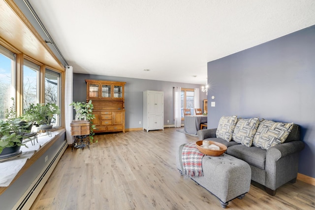 108 1st St, Kenyon, MN 55946 - living area featuring baseboard heating, baseboards, and light wood finished floors