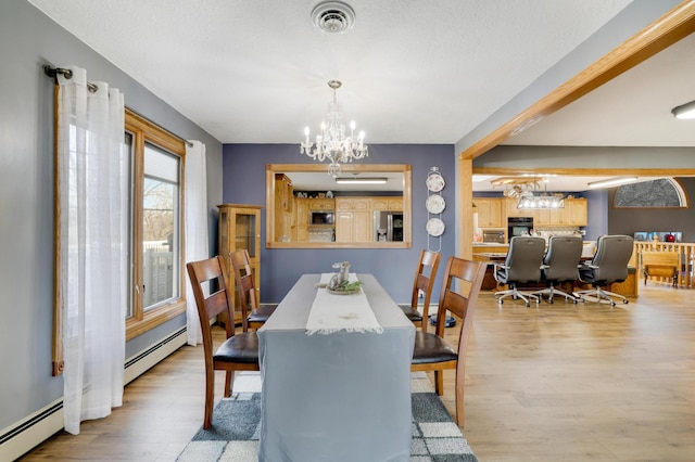 108 1st St, Kenyon, MN 55946 - dining area with a chandelier, a baseboard heating unit, and wood finished floors