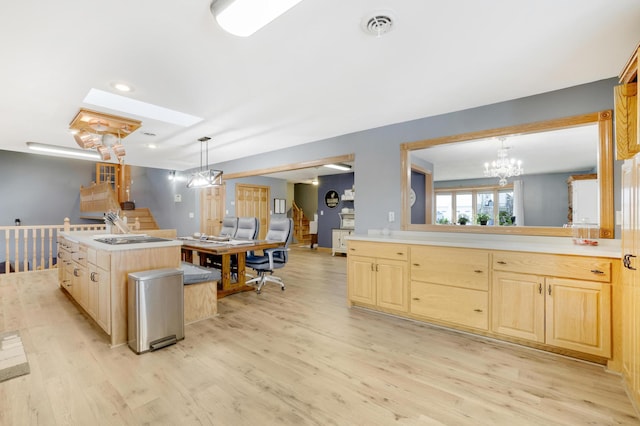 108 1st St, Kenyon, MN 55946 - kitchen featuring light brown cabinets, light wood finished floors, a chandelier, a skylight, and light countertops