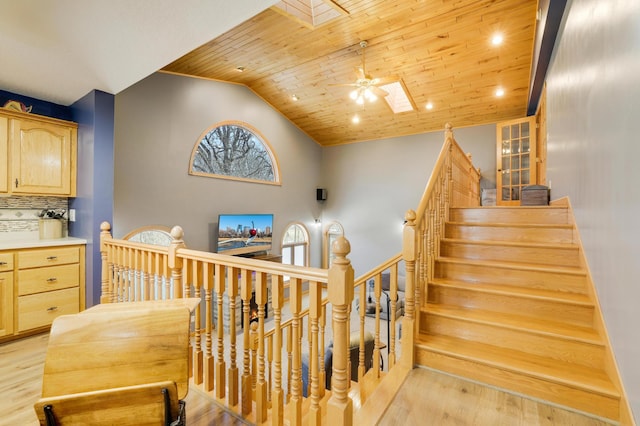 108 1st St, Kenyon, MN 55946 - staircase featuring wood finished floors, a ceiling fan, wood ceiling, lofted ceiling, and a skylight