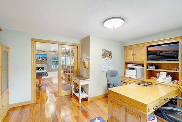 108 1st St, Kenyon, MN 55946 - home office with light wood-type flooring, baseboards, healthy amount of natural light, and a fireplace
