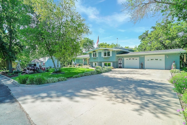 108 1st St, Kenyon, MN 55946 - tri-level home with an attached garage, concrete driveway, and a front lawn
