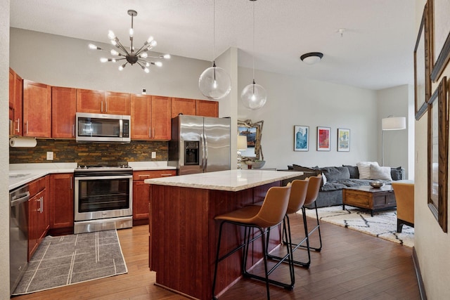 308 18th St Unit 202, Minneapolis, MN 55404 - kitchen with stainless steel appliances, dark wood-style floors, decorative backsplash, and light countertops