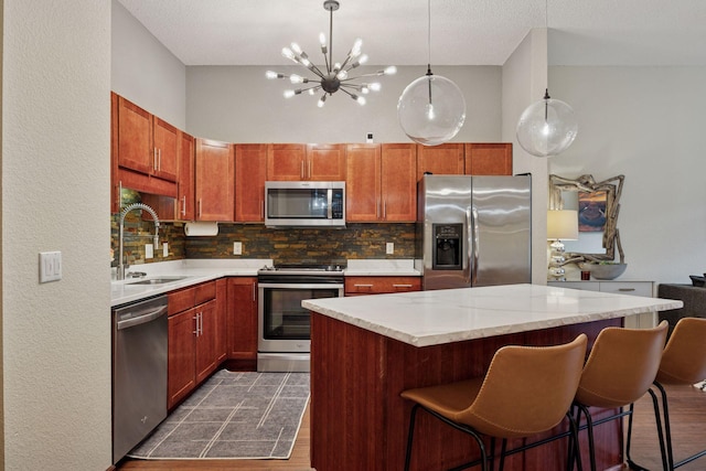308 18th St Unit 202, Minneapolis, MN 55404 - kitchen featuring appliances with stainless steel finishes, tasteful backsplash, dark wood-type flooring, a center island, and a breakfast bar area