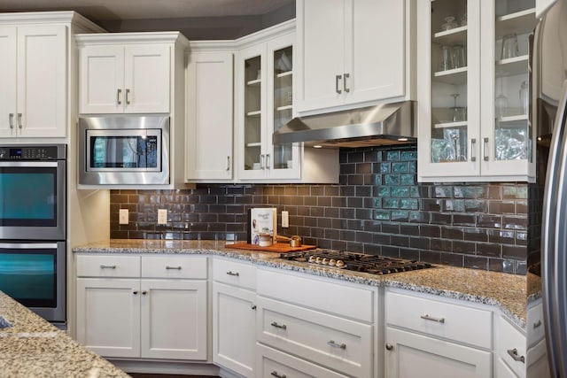 3365 Osgood Way N, Baytown Twp, MN 55082 - kitchen with appliances with stainless steel finishes, range hood, white cabinetry, and decorative backsplash