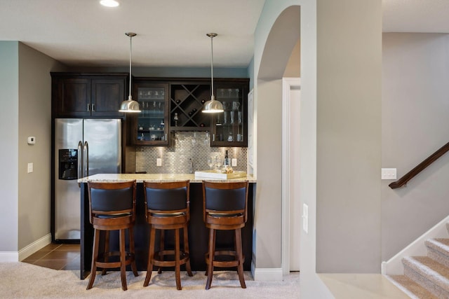 3365 Osgood Way N, Baytown Twp, MN 55082 - indoor wet bar with stainless steel refrigerator with ice dispenser, decorative backsplash, decorative light fixtures, and stairway