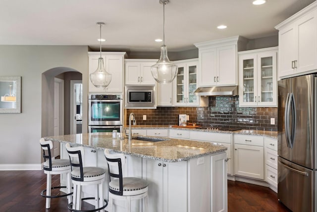 3365 Osgood Way N, Baytown Twp, MN 55082 - kitchen with stainless steel appliances, arched walkways, white cabinets, decorative backsplash, and recessed lighting