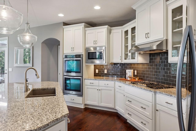 3365 Osgood Way N, Baytown Twp, MN 55082 - kitchen with appliances with stainless steel finishes, under cabinet range hood, dark wood finished floors, white cabinetry, and tasteful backsplash