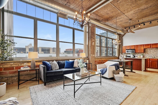 521 7th St Unit 420, Minneapolis, MN 55415 - living room featuring a chandelier, a towering ceiling, light wood finished floors, a view of city, and track lighting