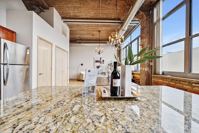 521 7th St Unit 420, Minneapolis, MN 55415 - kitchen with freestanding refrigerator, a chandelier, light stone countertops, and hanging light fixtures