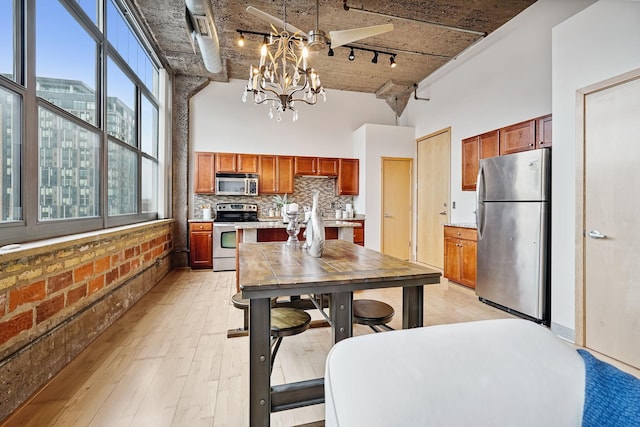 521 7th St Unit 420, Minneapolis, MN 55415 - kitchen featuring appliances with stainless steel finishes, rail lighting, a towering ceiling, a chandelier, and light countertops