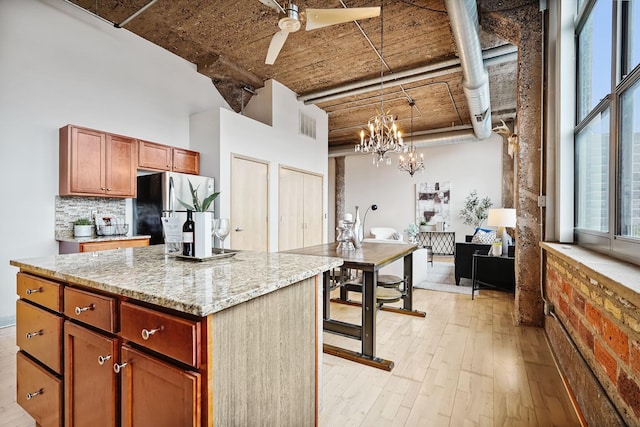 521 7th St Unit 420, Minneapolis, MN 55415 - kitchen featuring freestanding refrigerator, a high ceiling, light wood-style floors, hanging light fixtures, and backsplash