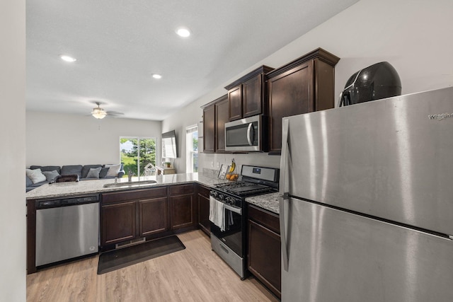 256 16th Ave SE, Lonsdale, MN 55046 - kitchen with appliances with stainless steel finishes, dark brown cabinets, light wood-style floors, open floor plan, and ceiling fan