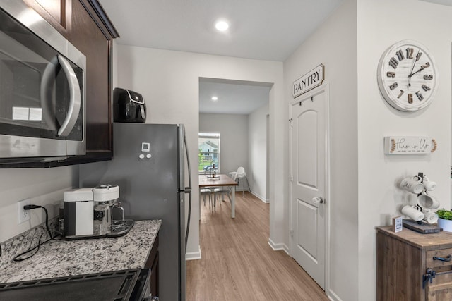 256 16th Ave SE, Lonsdale, MN 55046 - kitchen with stainless steel microwave, light wood-style flooring, dark brown cabinetry, light stone counters, and recessed lighting