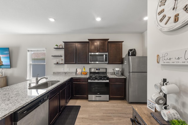256 16th Ave SE, Lonsdale, MN 55046 - kitchen with appliances with stainless steel finishes, dark brown cabinets, light stone counters, light wood-style flooring, and open shelves