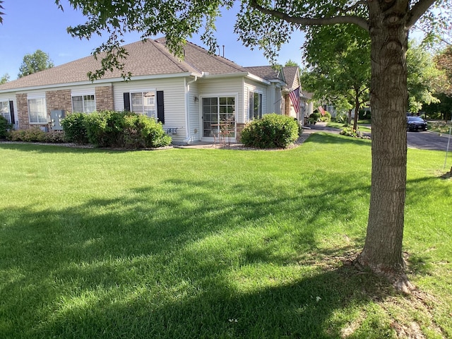 2009 Stahlke Way Unit 15, Chaska, MN 55318 - back of house featuring a lawn and a shingled roof