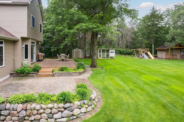 18250 221st Ave NW, Big Lake, MN 55309 - view of green lawn featuring a shed, a playground, a patio, and a wooden deck