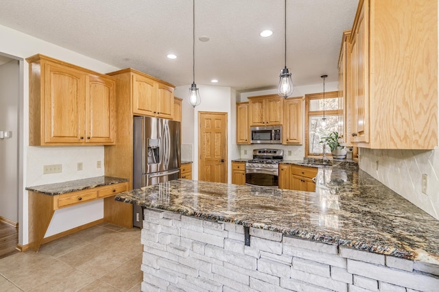 18250 221st Ave NW, Big Lake, MN 55309 - kitchen featuring stainless steel appliances, a peninsula, dark stone countertops, tasteful backsplash, and pendant lighting