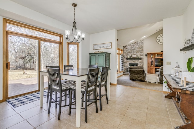 18250 221st Ave NW, Big Lake, MN 55309 - dining area featuring a chandelier, lofted ceiling, a fireplace, and light tile patterned flooring
