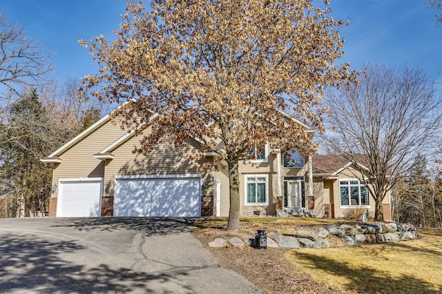 18250 221st Ave NW, Big Lake, MN 55309 - obstructed view of property featuring driveway, an attached garage, and brick siding