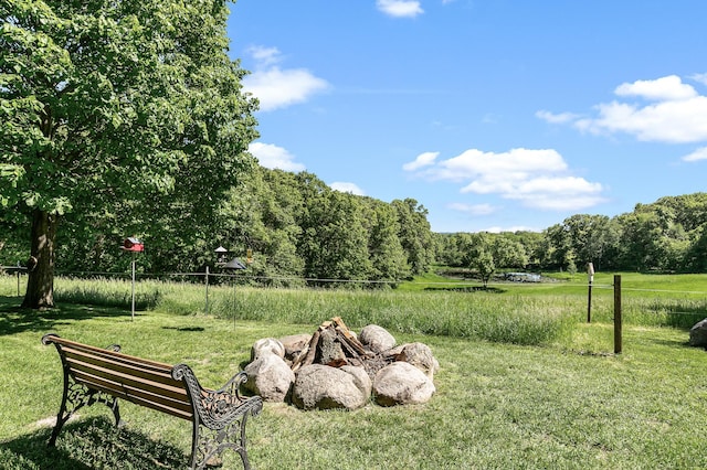 15015 Held Cir, Cold Spring, MN 56320 - view of green lawn with an outdoor fire pit and a wooded view
